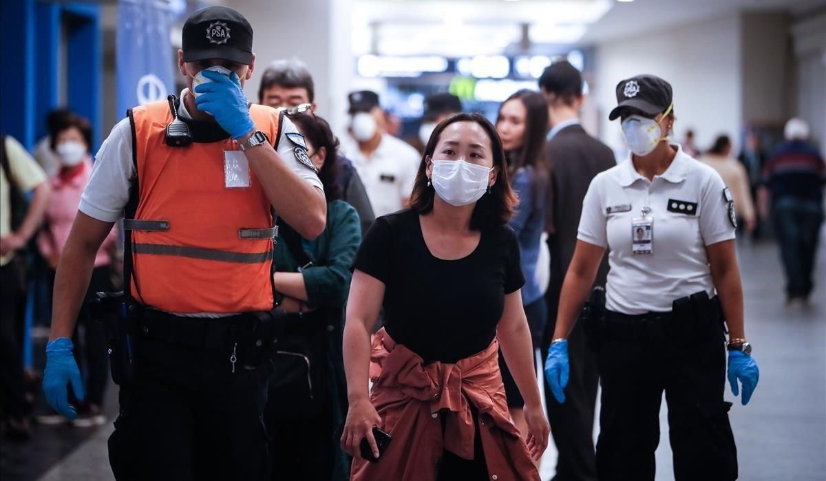 Policías argentinos separan a turistas europeos a su llegada al aeropuerto Jorge Newbery de Buenos Aires, en prevención por la pandemia de coronavirus. Policías argentinos separan a turistas europeos a su llegada al aeropuerto Jorge Newbery de Buenos Aires, en prevención por la pandemia de coronavirus.