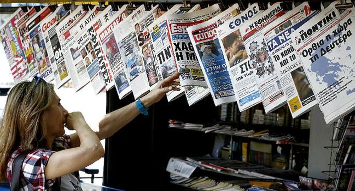 Una mujer mira con curiosidad y cierto temor la oferta informativa de la prensa griega. Una mujer mira con curiosidad y cierto temor la oferta informativa de la prensa griega.
