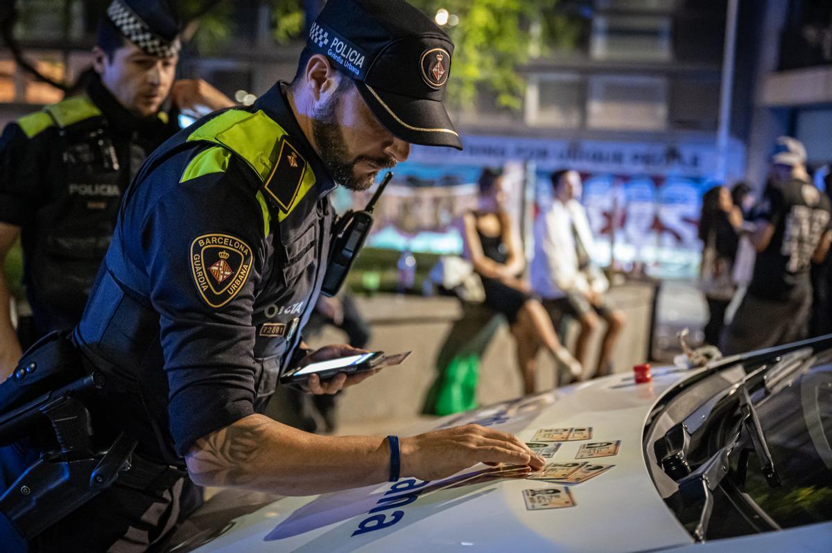Una agente realiza una identificación en una plaza de Ciutat Vella, con su pistola debidamente resguardada en la funda