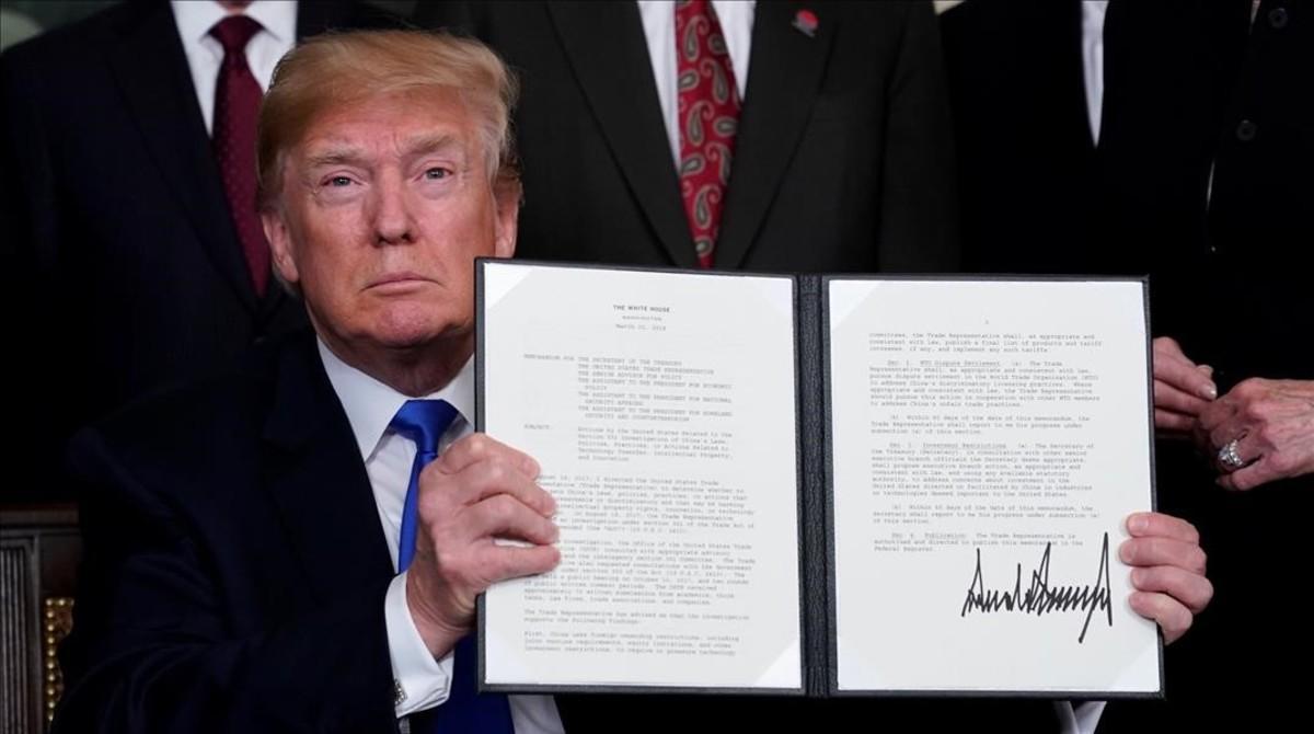 Donald Trumpo muestra su firma en el mermorándum sobre China.