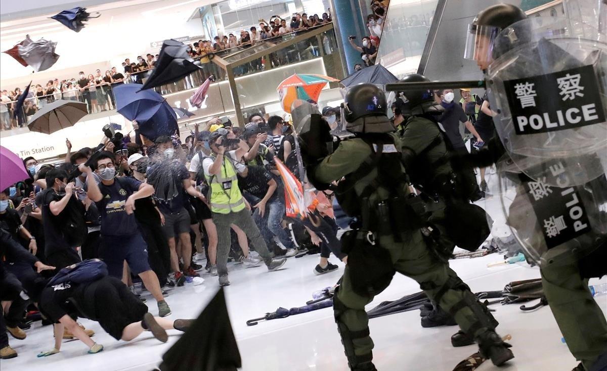 La policía antidisturbios trata de dispersar a activistas hongkoneses que protestan contra el Gobierno chino. 