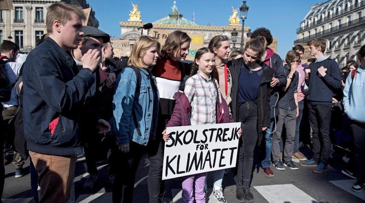 La activista sueca Greta Thunberg sostiene una pancarta junto a varios estudiantes franceses que participan en una marcha contra el cambio climático en París, el 22 de febrero.