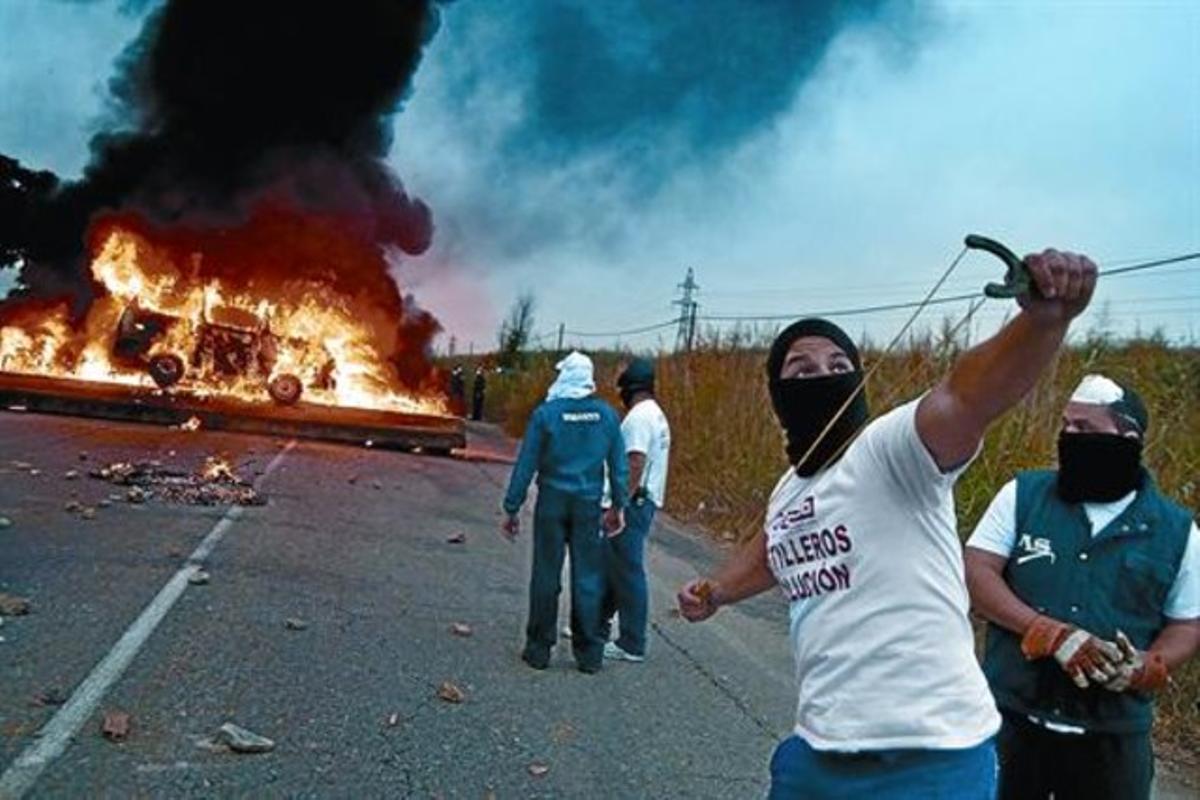 Trabajadores de astilleros cortan una carretera de acceso al puerto de Sevilla, en septiembre. Trabajadores de astilleros cortan una carretera de acceso al puerto de Sevilla, en septiembre.