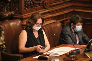 La alcaldesa de Barcelona, Ada Colau, observa su móvil en un pleno municipal.