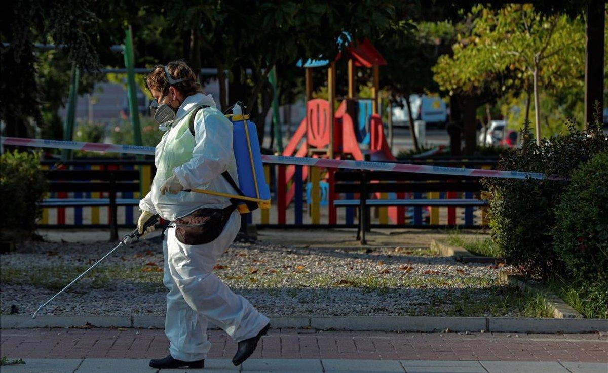 Una trabajadora municipal desinfecta los alrededores de un parque infantil en la localidad madrileña de Alcobendas.