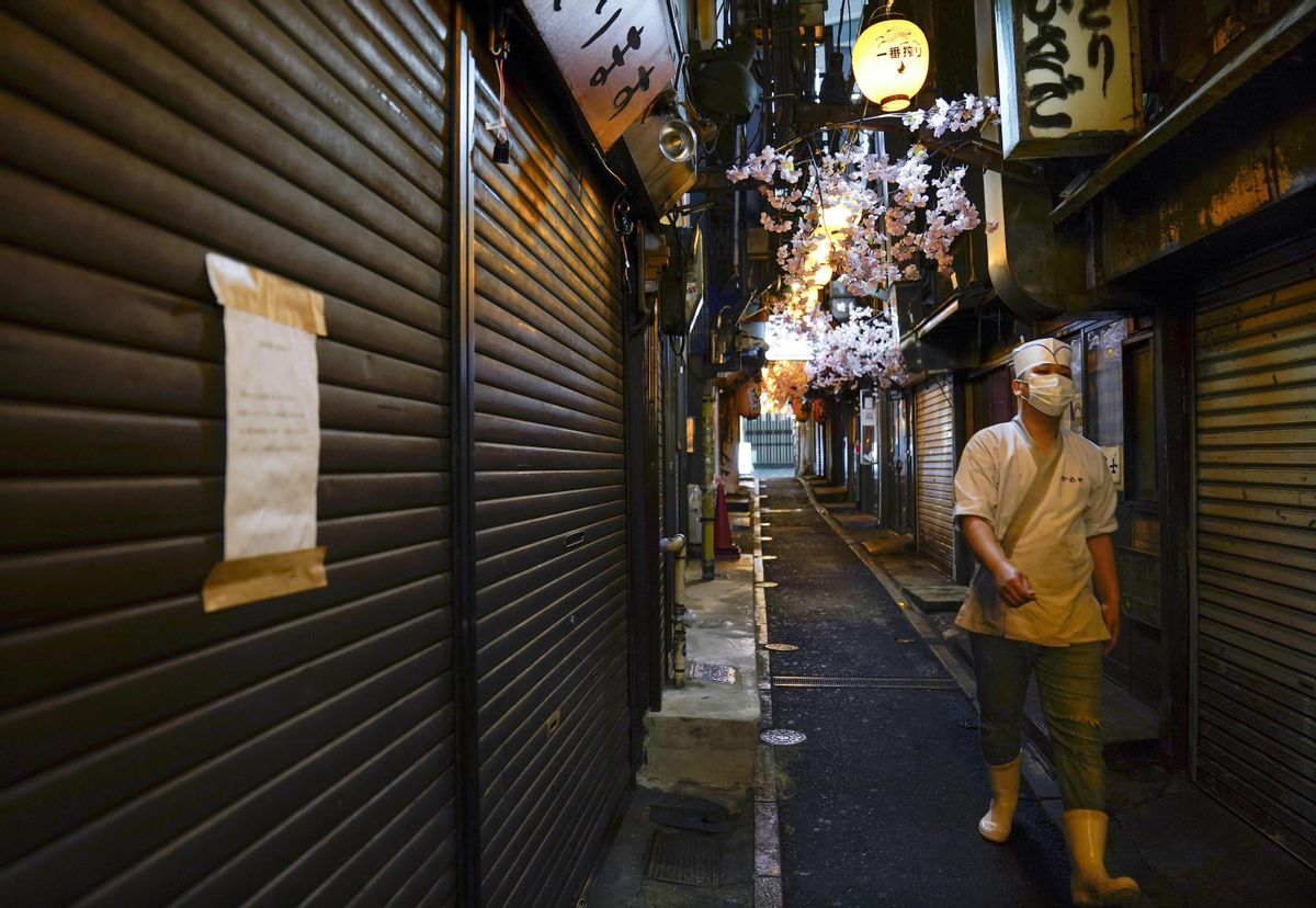 Un trabajador de un restaurante pasea por una zona de hostelería cerrada en Tokio Un trabajador de un restaurante pasea por una zona de hostelería cerrada en Tokio