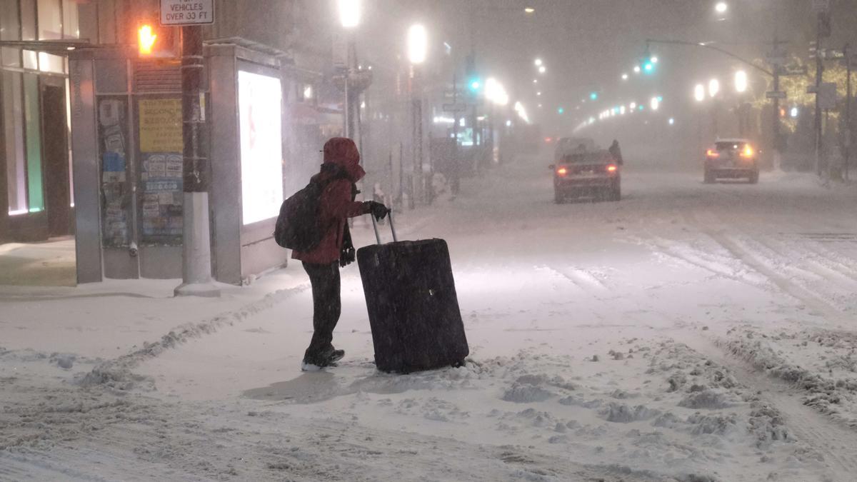 Una mujer transporta un maleta bajo el temporal de nieve en Nueva York