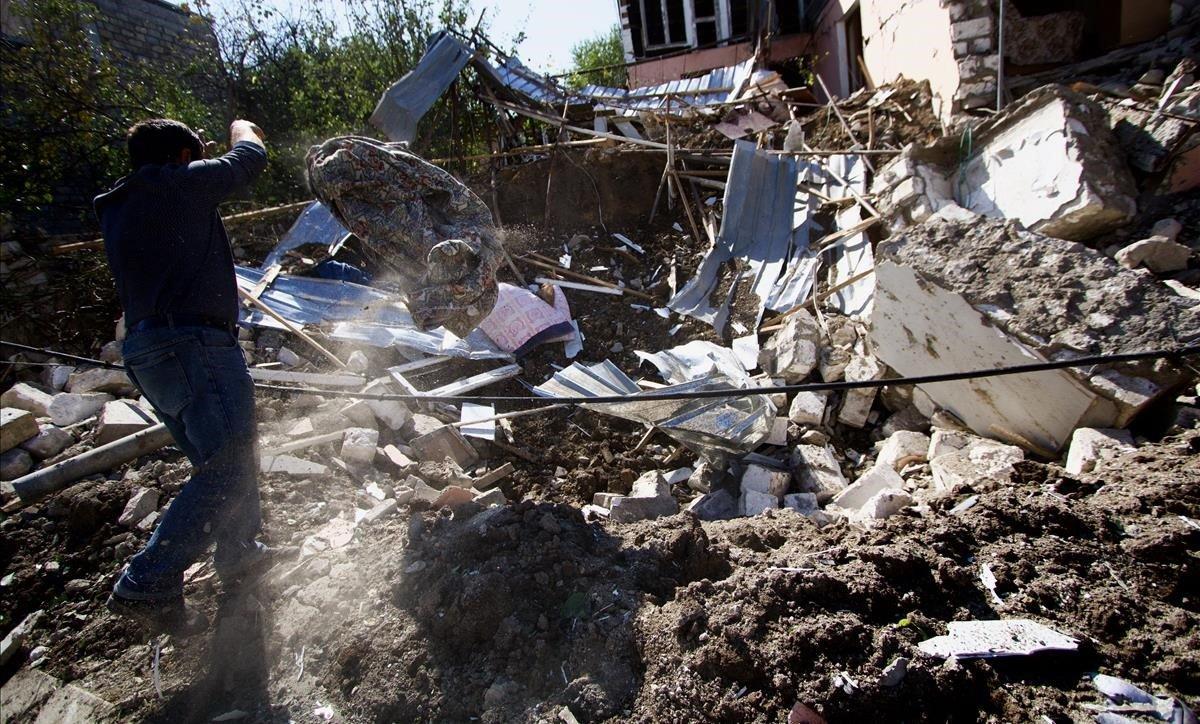 Un hombre busca enseres entre los escombros de su casa derrumbada en los bombardeos de Stepanakert.