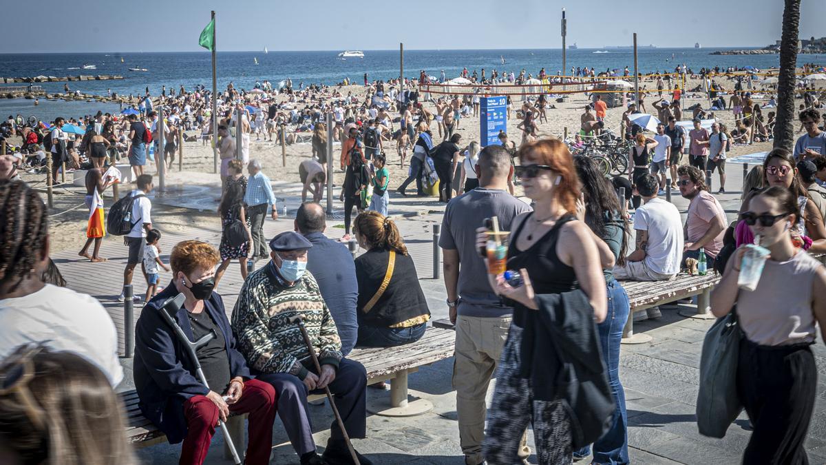 Personas pasean con y sin mascarilla por el Paseo Marítimo de la Barceloneta, el 1 de mayo.