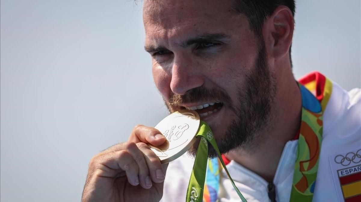 Saúl Craviotto, comprobando los quilates de la medalla. Saúl Craviotto, comprobando los quilates de la medalla.
