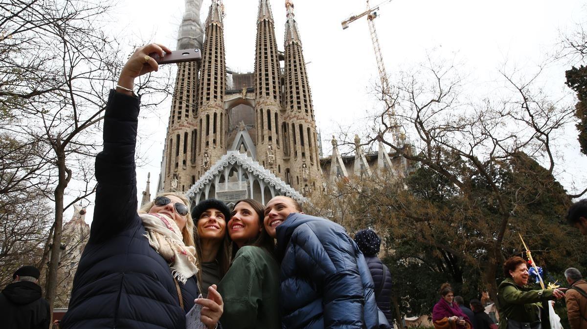 Una familia se fotografía al pie de la Sagrada Família.