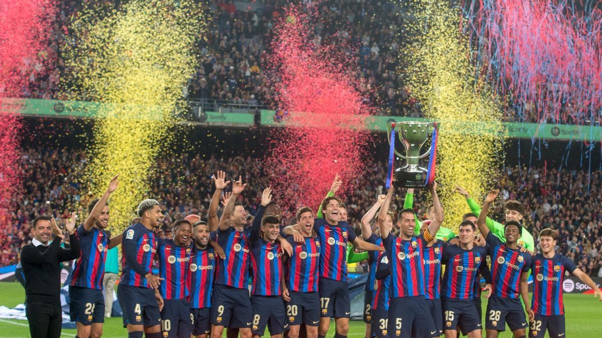Busquets alza el trofeo de la Liga en el Camp Nou ante sus compañeros y Xavi.