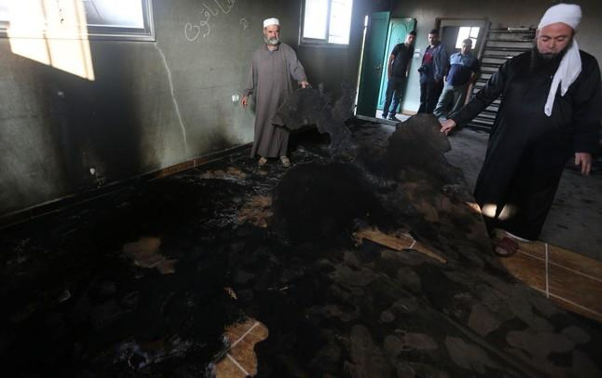 Un grupo de Palestinos musulmanes examina los daños causado por el incendio en la mezquita en Aqraba. Un grupo de Palestinos musulmanes examina los daños causado por el incendio en la mezquita en Aqraba.