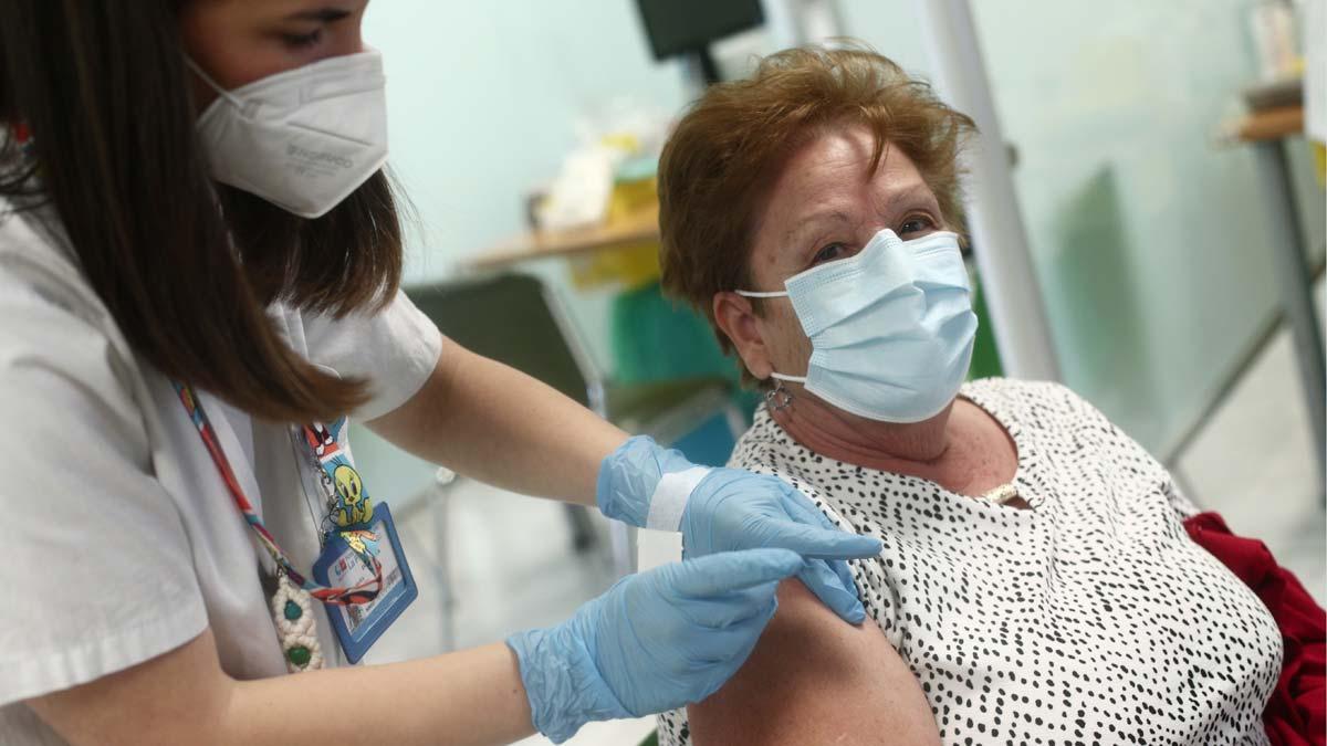 Una enfermera inocula con la vacuna de Pfizer a una mujer en Madrid.
