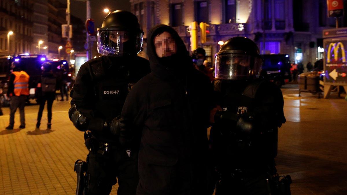 Seis noches de disturbios en Barcelona en protestas contra la detención de Pablo Hasél. En la foto, agentes de los Mossos se llevan a un detenido.