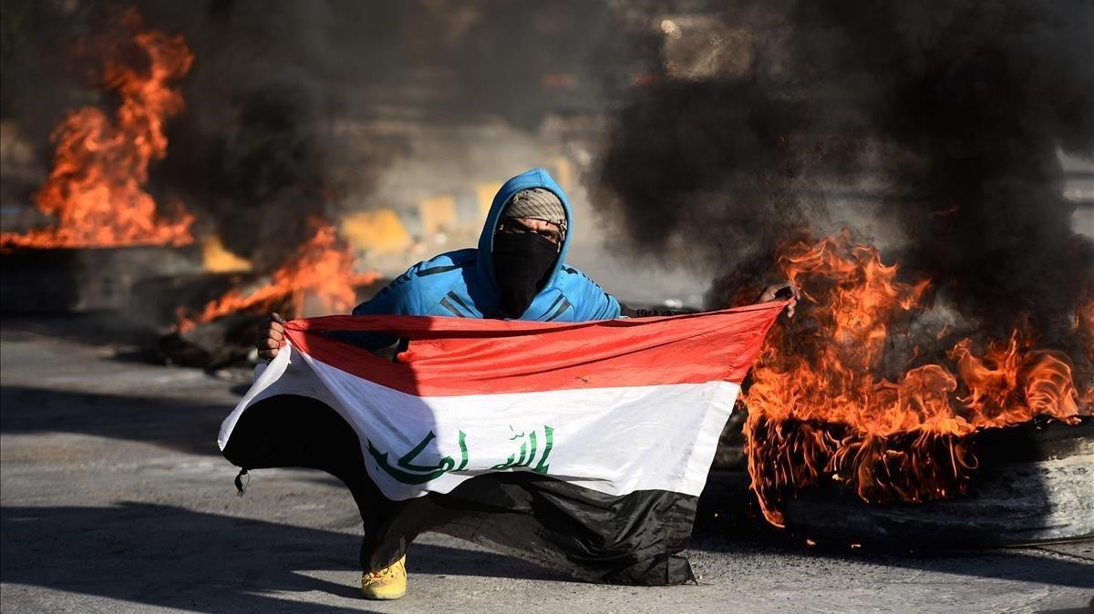 Un manifestante muestra la bandera iraquí en una protesta para evitar que Irak se convierta en el escenario de la guerra en Irán y EEUU.