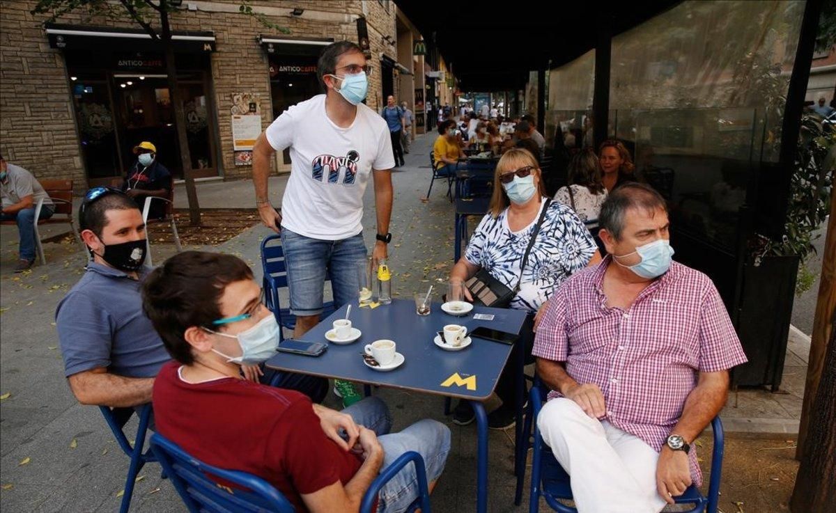 Un grupo de personas con mascarilla toma algo en una terraza de Barcelona. Un grupo de personas con mascarilla toma algo en una terraza de Barcelona.