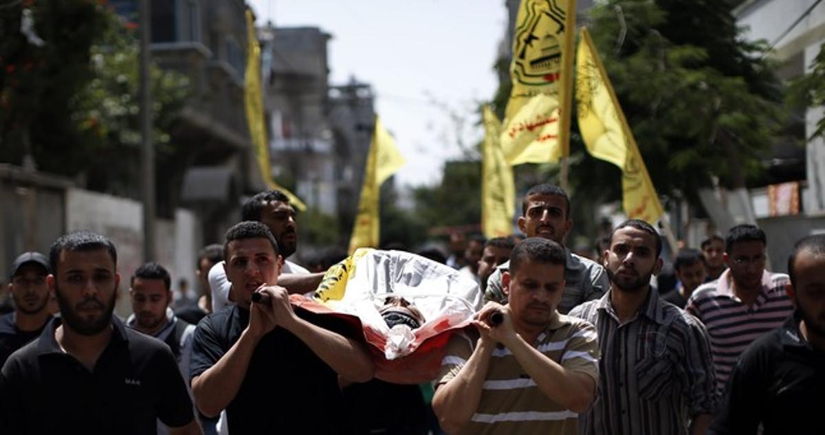 Familiares de un palestino muerto en Gaza llevan a hombros el cadáver durante el funeral, este sábado.