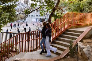 Alumnas del centro concertado Garbí bajan las escaleras del patio, con vistas a las instalaciones del instituto de alta complejidad Joanot Martorell, en Esplugues.