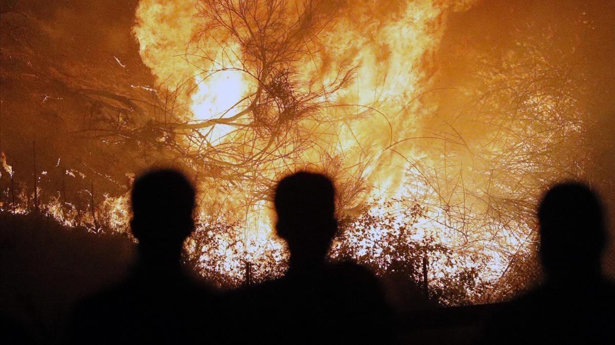 Personas observan impresionados el incendio en Chandebrito. 