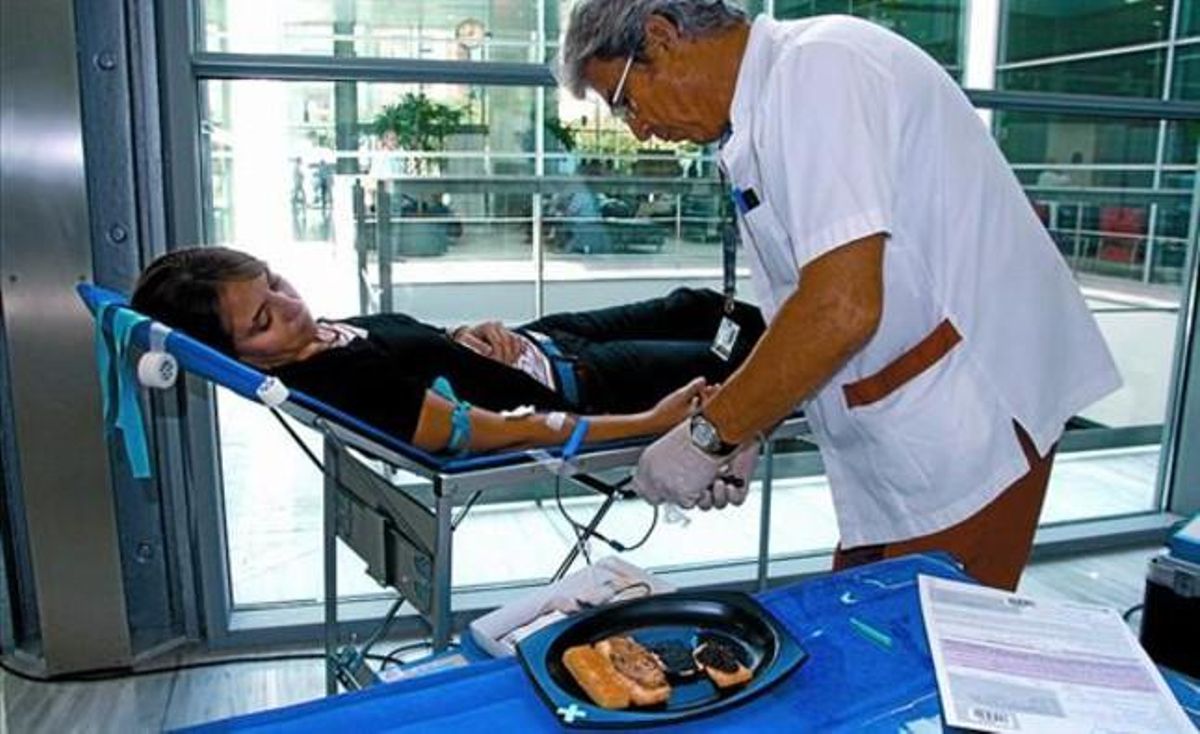 El enfermero Gabriel pincha a la joven Clara mientras las tapitas la esperan, ayer en el hospital de Sant Pau. El enfermero Gabriel pincha a la joven Clara mientras las tapitas la esperan, ayer en el hospital de Sant Pau.