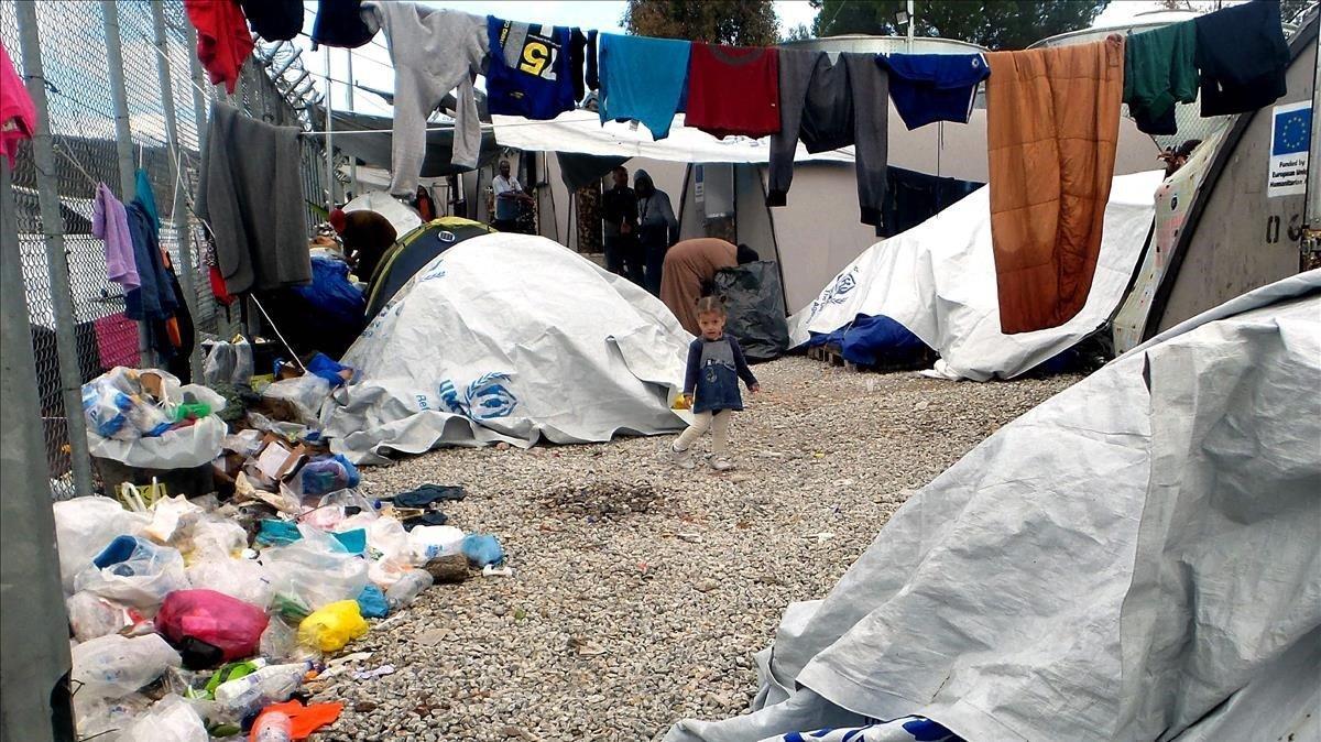 Un niña se encuentra entre las carpas en un campamento improvisado fuera del campamento de migrantes Moria en la isla de Lesbos