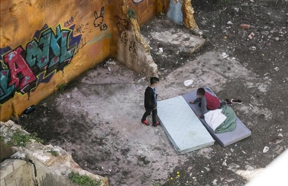 Dos chicos descansan en un colchón en un solar junto al Pou de la Figuera, cerca del mercado de Santa Caterina, en una imagen del 2016. Dos chicos descansan en un colchón en un solar junto al Pou de la Figuera, cerca del mercado de Santa Caterina, en una imagen del 2016.