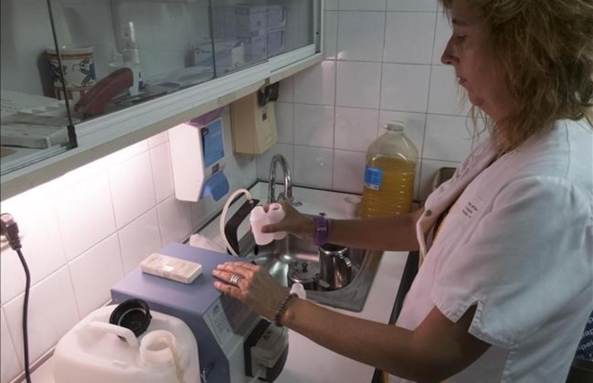 Chefa, enfermera del CAS de La Mina, prepara una dosis de metadona, que mezclará con zumo de naranja.