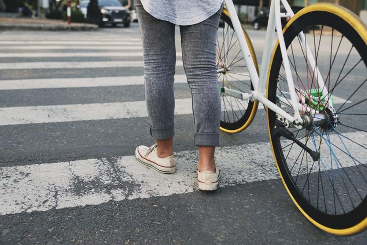 Un ciclista cruza un paso de peatones de manera correcta.