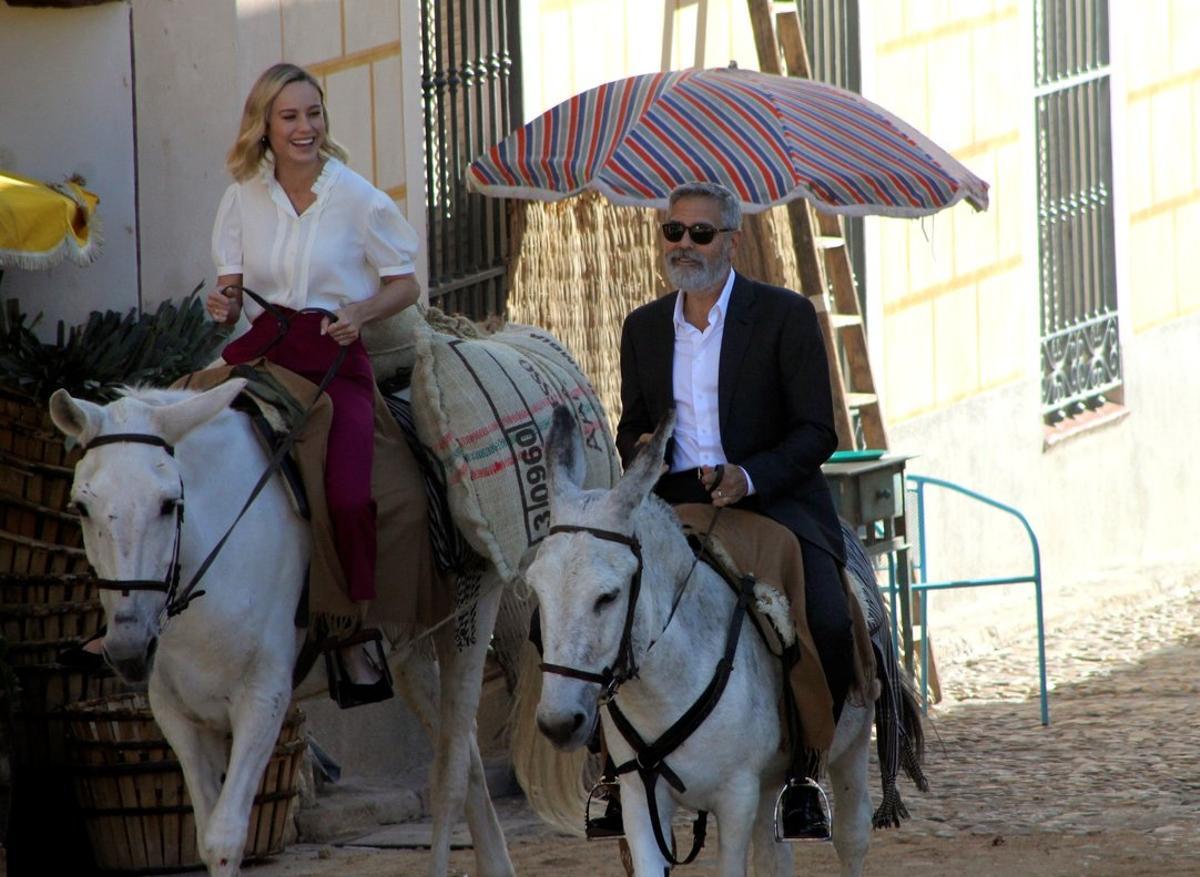 George Clooney y Brie Larson, a lomos de sendos burros, por el centro de Navalcarnero (Madrid).