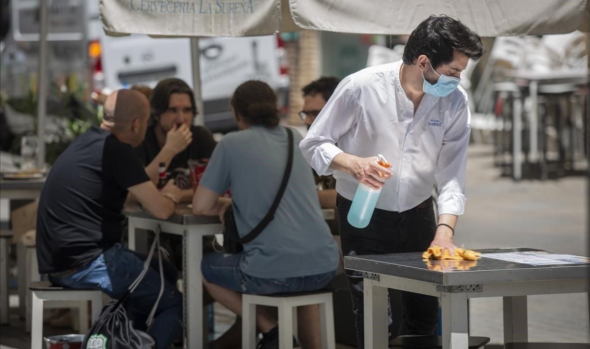 Un camarero desinfecta la mesa de una terraza, el pasado lunes. Un camarero desinfecta la mesa de una terraza, el pasado lunes.