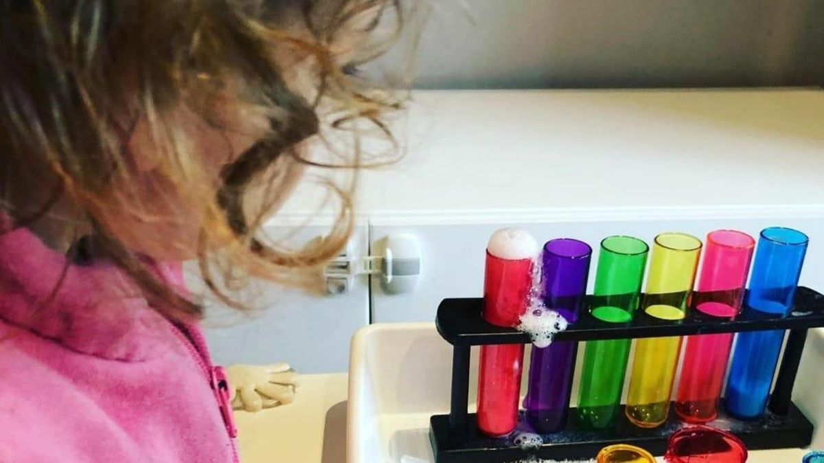 Una niña mira un experimento. Una niña mira un experimento.