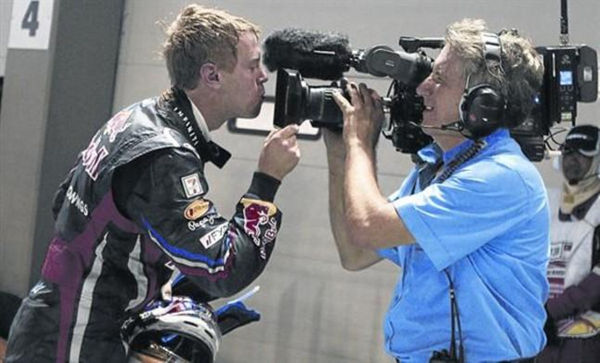 El tetracampeón alemán Sebastian Vettel besa el objetivo de una cámara del Mundial de F-1 tras ganar el GP de Singapur del 2011. El tetracampeón alemán Sebastian Vettel besa el objetivo de una cámara del Mundial de F-1 tras ganar el GP de Singapur del 2011.