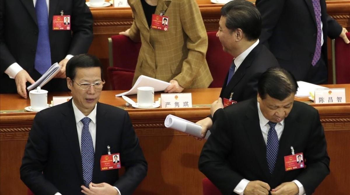 Xi pasa junto a los miembros del Politburó Liu Yunshan (derecha) y Zhang Gaoli (izquierda), en la sesión plenaria de la Asamblea Nacional Popular de China, en Pekín, el 13 de marzo del 2016.