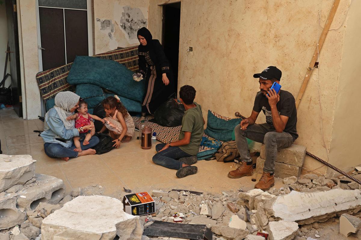 Wissam Joudeh (derecha) junto a su familia en su casa parcialmente destruida, en Rafah.