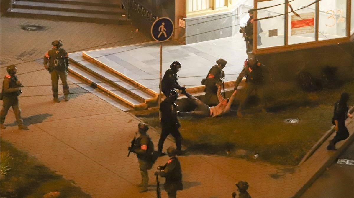 La policía antidisturbios se lleba arrastras a un manifestantes en Minks- La policía antidisturbios se lleba arrastras a un manifestantes en Minks-