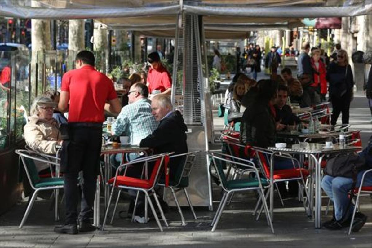 Varios camareros sirven a clientes en terrazas de bares del paseo de Gràcia. Varios camareros sirven a clientes en terrazas de bares del paseo de Gràcia.