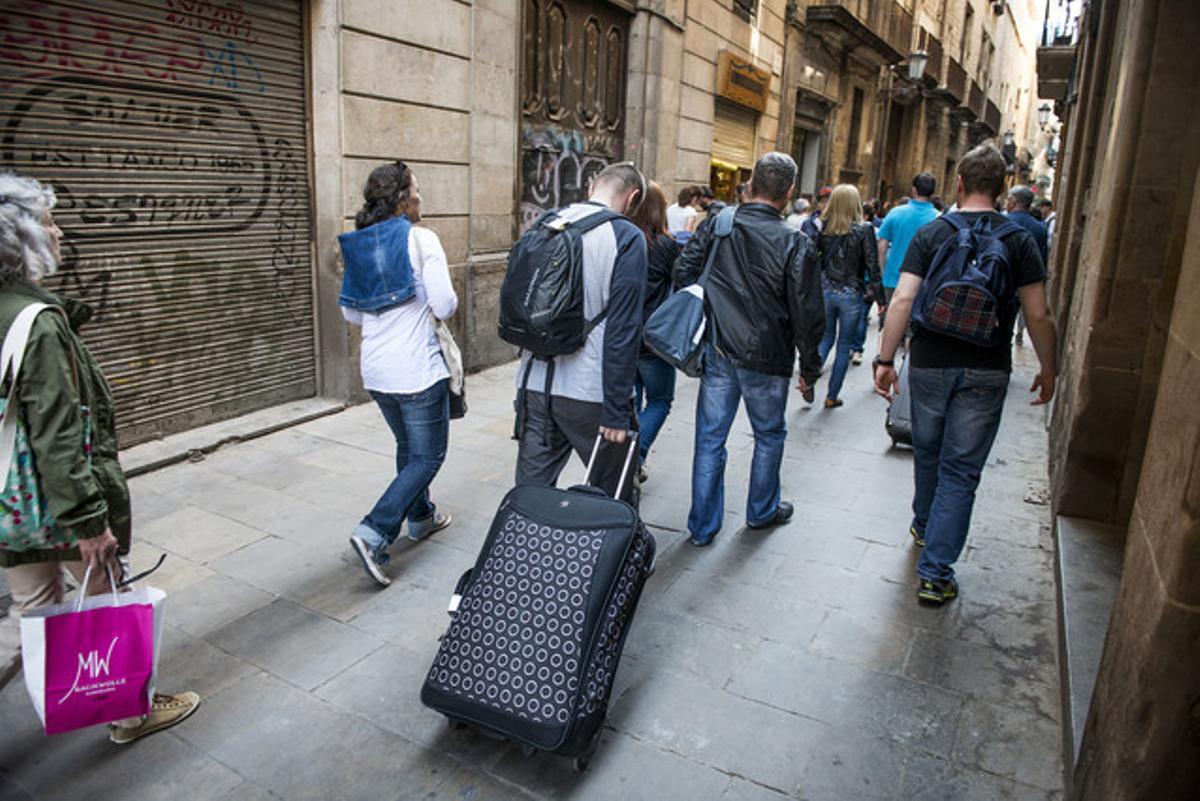 Turistas con maletas en el centro de Barcelona.