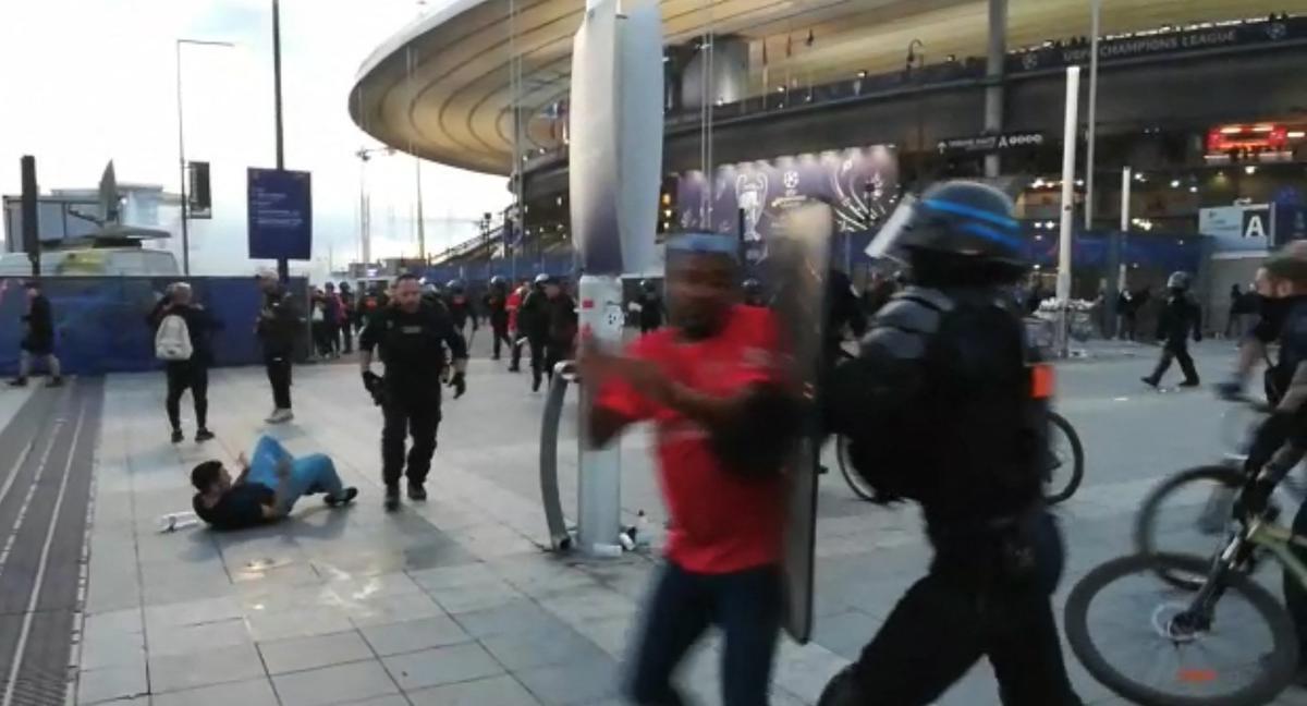 sta captura tomada de un video de AFP muestra a la policía interviniendo mientras los fanáticos trepan la valla del Stade de France antes del partido de fútbol final de la UEFA Champions League