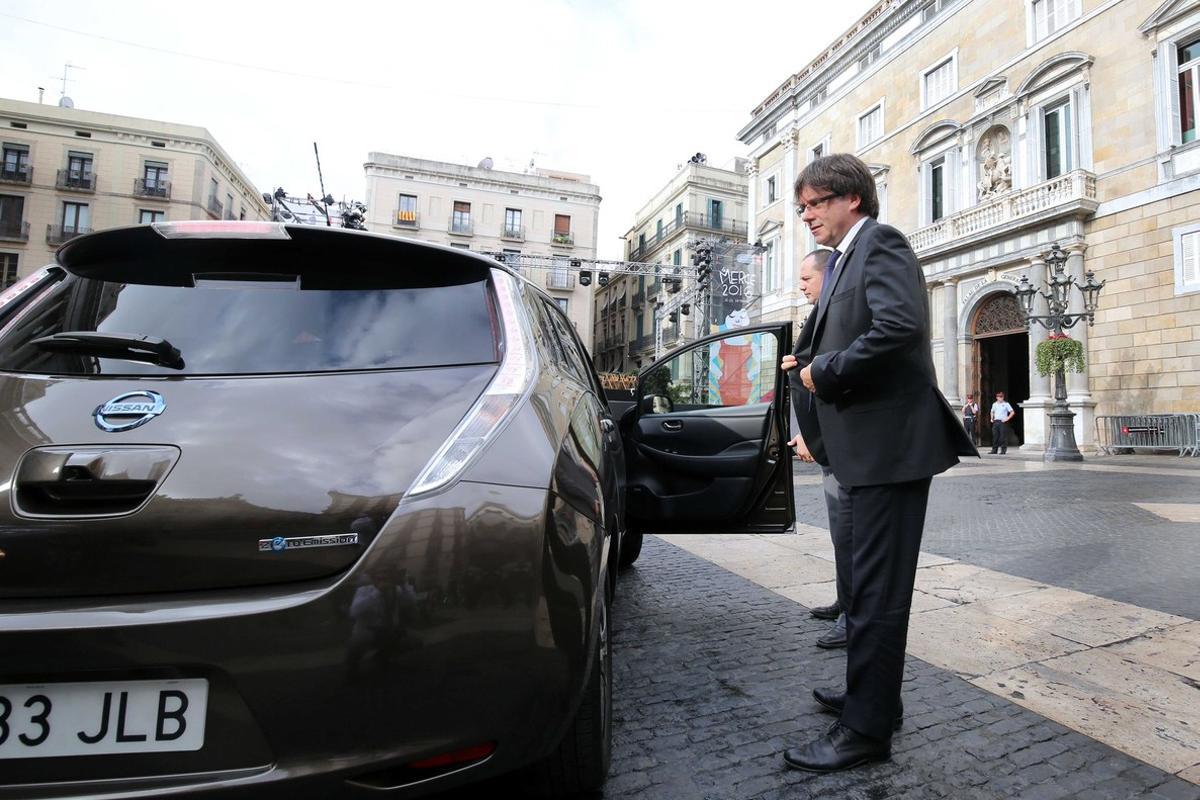 El ’president’ de la Generalitat junto al coche eléctrico con el que se ha dirigido a la Generalitat