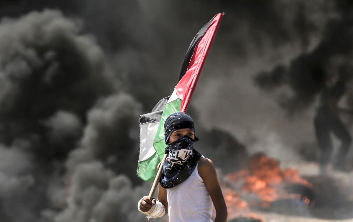 Un niño con la bandera palestino durante los choques con el Ejército israelí en la frontera de Gaza. Un niño con la bandera palestino durante los choques con el Ejército israelí en la frontera de Gaza.