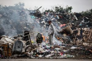 Un hombre recoge elementos que puedan ser de utilidad en un basurero, en una Villa de la Ciudad de Buenos Aires.