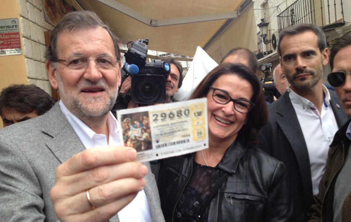 Mariano Rajoy recibe un décimo de lotería durante su recorrido por Estepona (Málaga). Mariano Rajoy recibe un décimo de lotería durante su recorrido por Estepona (Málaga).