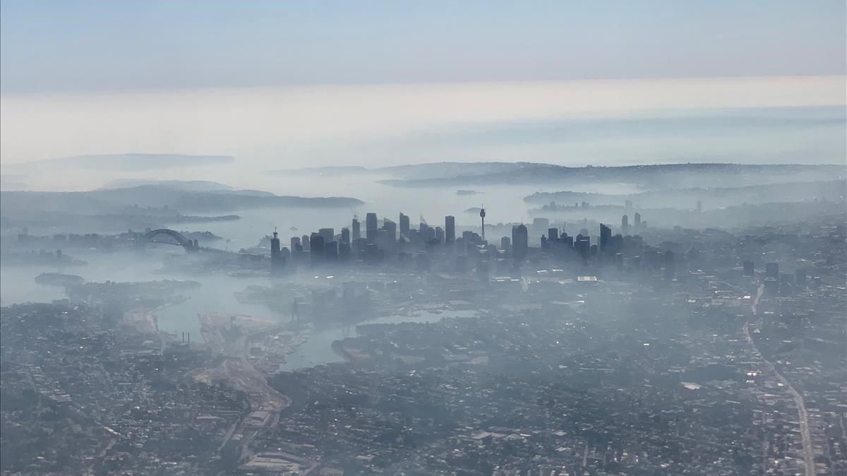Imagen aérea de la ciudad de Sídney cubierta por una densa nube de humo blanco, este martes. Imagen aérea de la ciudad de Sídney cubierta por una densa nube de humo blanco, este martes.