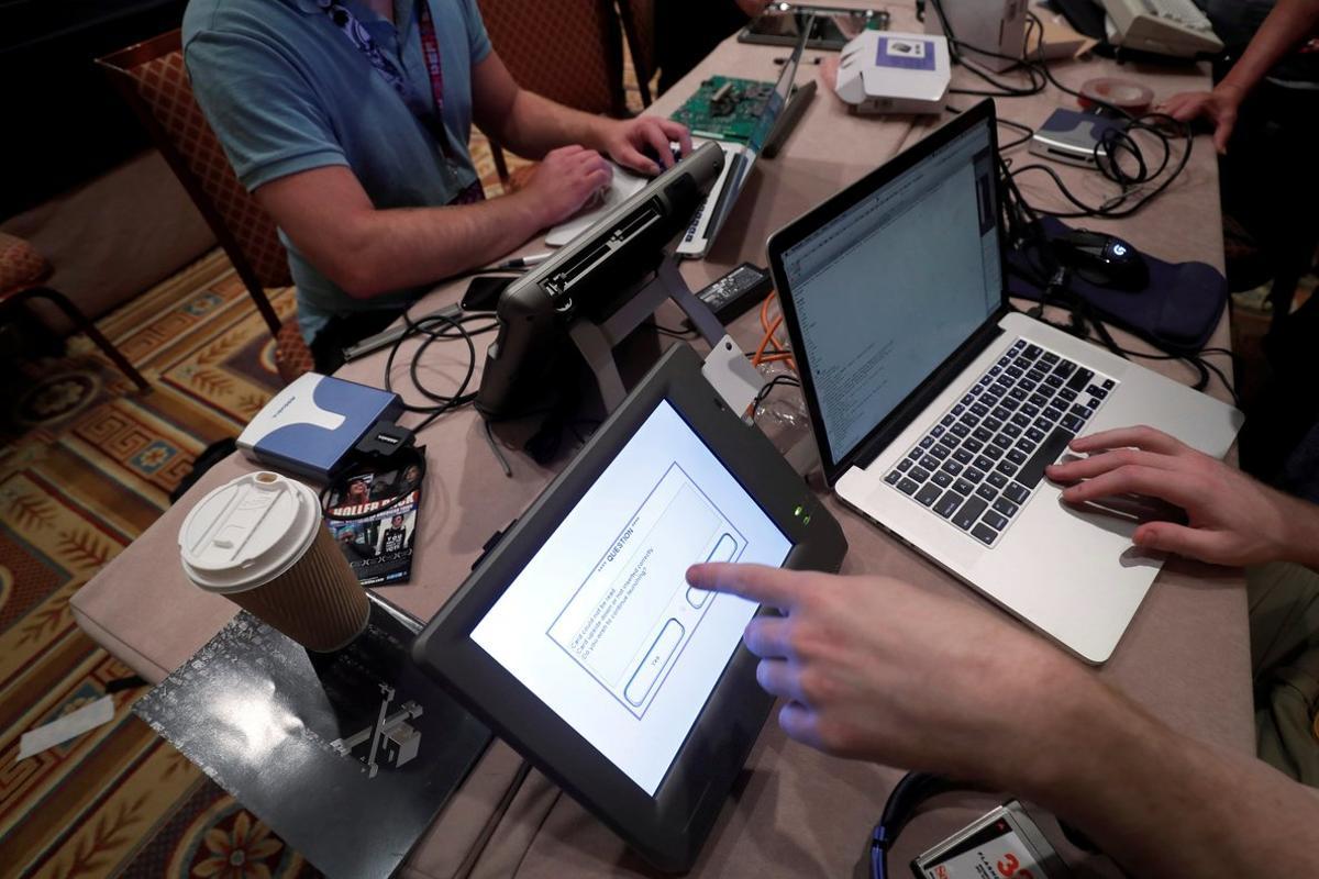 FILE PHOTO: Hackers try to access and alter data from an electronic poll books in a Voting Machine Hacking Village during the Def Con hacker convention in Las Vegas, Nevada, U.S., July 29, 2017. REUTERS/Steve Marcus/File Photo