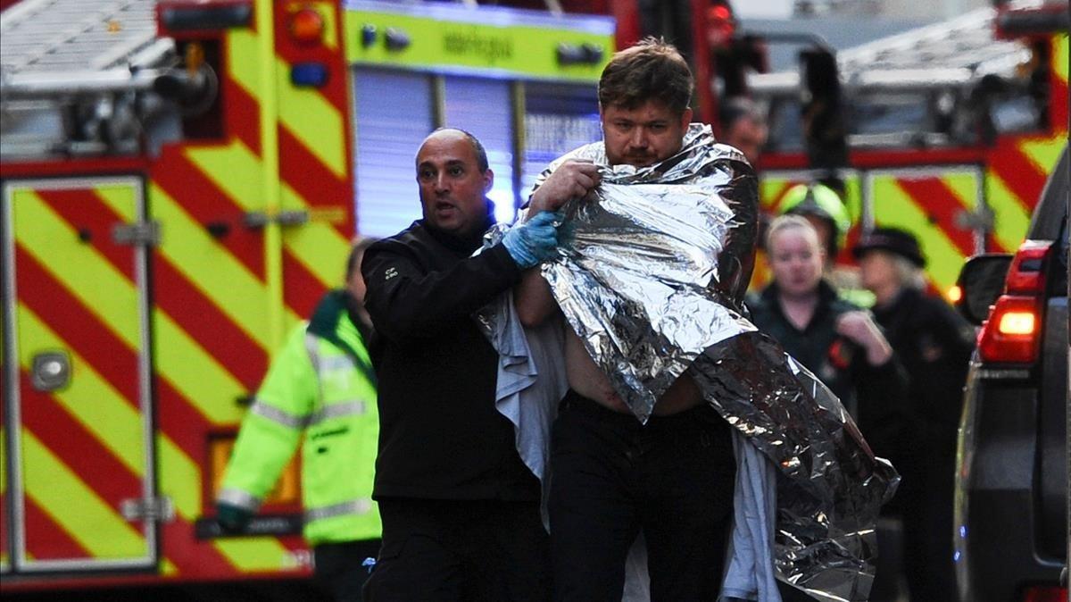 La policía asiste a un hombre herido en el ataque en el Puente de Londres, este viernes.