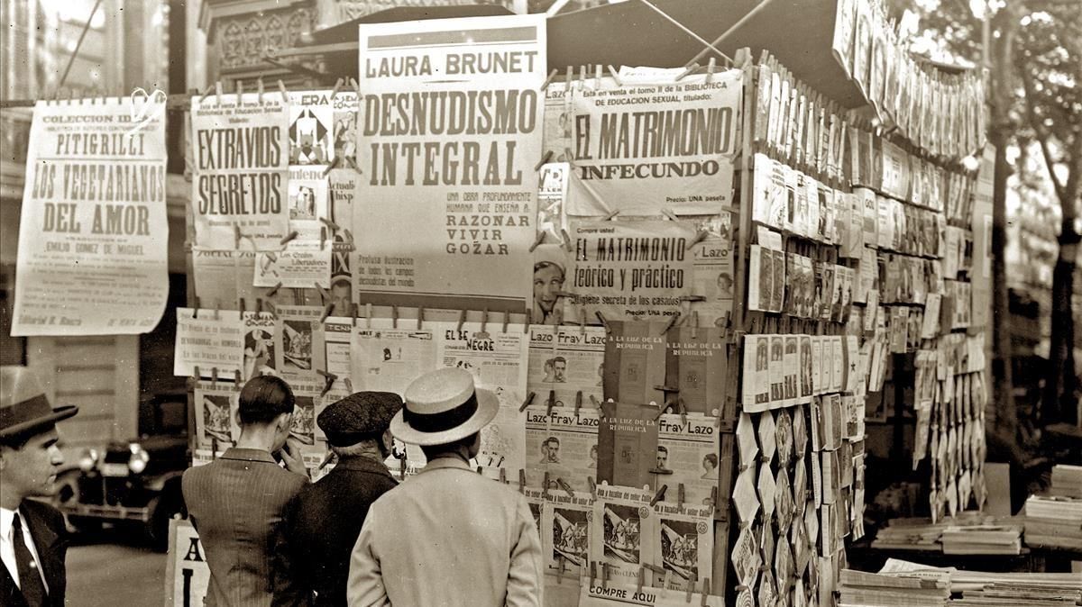 Lectura de diarios y revistas en un quiosco de las Ramblas hace un siglo. Lectura de diarios y revistas en un quiosco de las Ramblas hace un siglo.