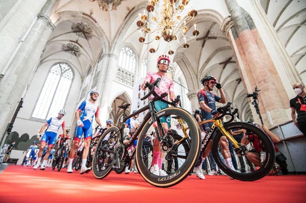 Los ciclistas cruzan a pie la iglesia protestante de Nuestra Señora, en Breda, durante el recorrido neutralizado de la tercera etapa de la Vuelta.