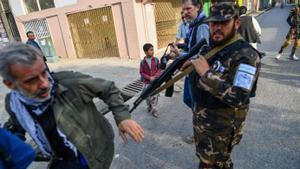 Un miembro de los talibanes empuja a un periodista que cubre una manifestación de mujeres  frente a una escuela en Kabul el 30 de septiembre de 2021