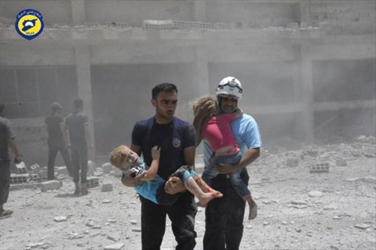 Voluntarios de la Defensa Civil con niños, tras un bombardeo en Daraa. Voluntarios de la Defensa Civil con niños, tras un bombardeo en Daraa.